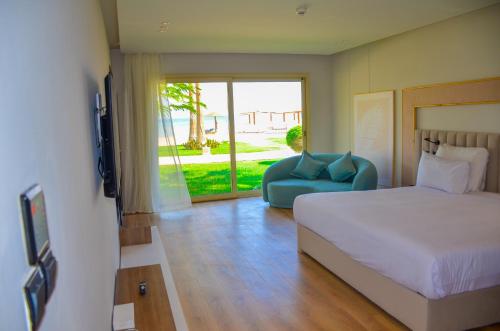 a bedroom with a bed and a couch and a tv at Shams Prestige Abu Soma (Adults Only) in Hurghada