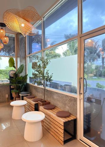 a restaurant with two benches and a large window at Palm Scenery Resort in Takua Pa