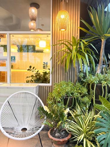 a white chair in a room with plants at Palm Scenery Resort in Takua Pa