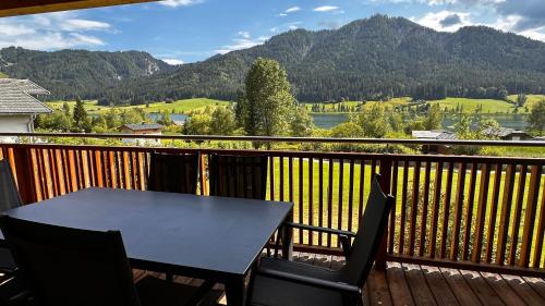 a table and chairs on a balcony with a view at Premium Apartments am Weißensee in Weissensee