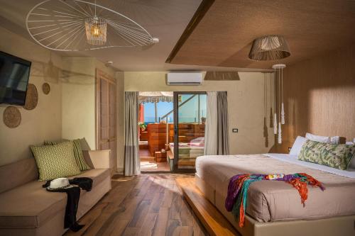 sypialnia z dużym łóżkiem i kanapą w obiekcie Esperides Resort Crete, The Authentic Experience w mieście Hersonissos