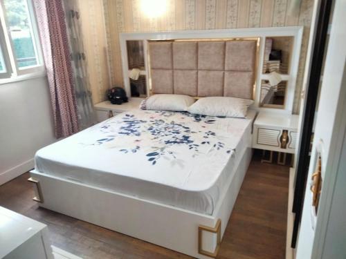 a bedroom with a large white bed with blue flowers at Maison et Appartement in La Courneuve