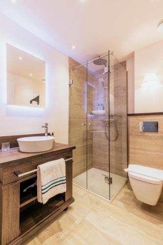a bathroom with a sink and a toilet and a shower at Grand Hotel Opduin in De Koog