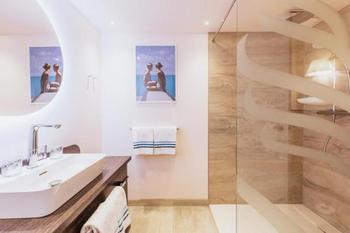 a bathroom with a sink and a shower at Grand Hotel Opduin in De Koog