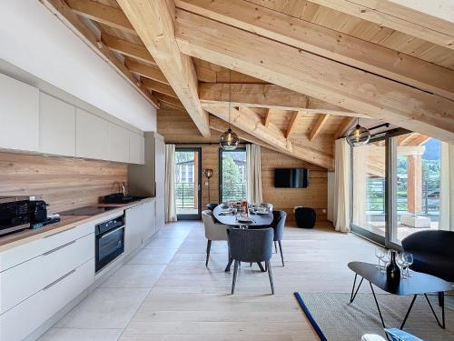 une cuisine et une salle à manger avec une table et des chaises dans l'établissement Cedrela-appartement-5-7pers-Centre station, aux Gets