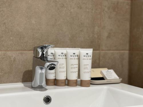 un évier avec un robinet et trois livres dessus dans l'établissement Cedrela-appartement-5-7pers-Centre station, aux Gets