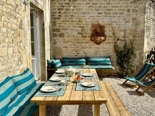 - une table en bois avec des assiettes et de la vaisselle dans l'établissement Un mouton dans l'eglise, à Putot-en-Bessin