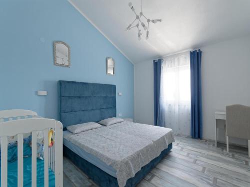 a bedroom with a bed and a blue wall at Villa Matthias by Rent Istria in Ližnjan