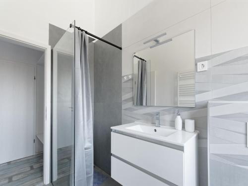 a white bathroom with a sink and a mirror at Villa Matthias by Rent Istria in Ližnjan