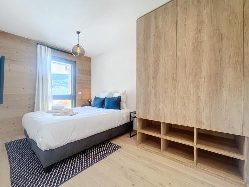 - une chambre avec un lit et un grand mur en bois dans l'établissement Corylus-appartement-4Pers-Centre Station, aux Gets