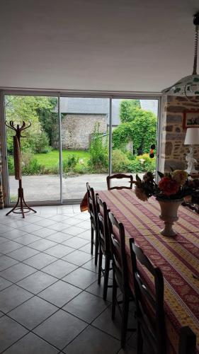 une salle à manger avec une table et des chaises et une grande fenêtre dans l'établissement Chambre d'Hôtes La Closerie, à Tourneville