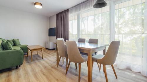 a living room with a dining room table and chairs at Apartamenty Helski Brzeg in Hel