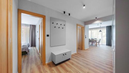 a white room with a bed and a table at Apartamenty Helski Brzeg in Hel