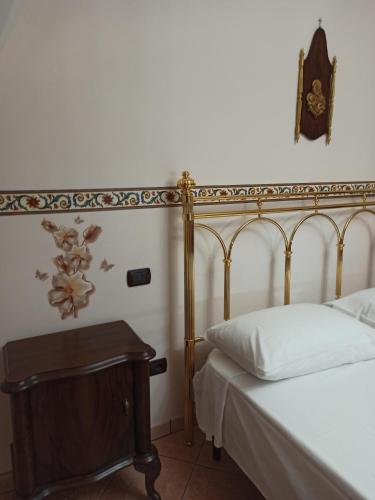 a bedroom with a bed and a table with a clock on the wall at Meraviglie Salentine in Lequile