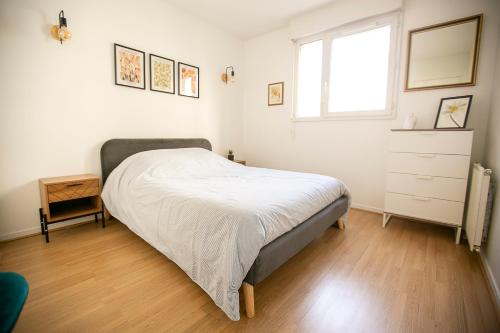 - une chambre avec un lit, une fenêtre et une commode dans l'établissement Jerickais appartement à la Défense, à Courbevoie