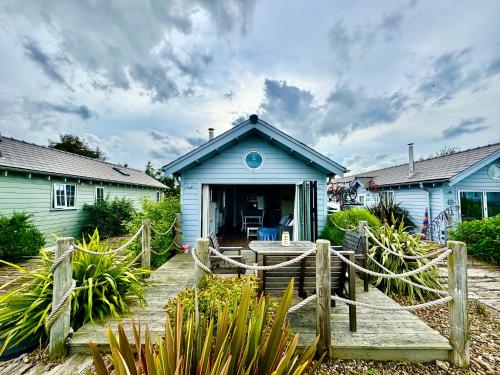 a blue house with a wooden walkway in front of it at Secret Of Eden Seaside Escape in Filey