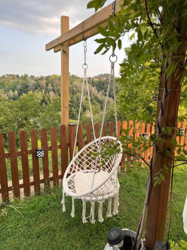 a white basket swing hanging from a wooden fence at B&B TERRA DI COLLINA in Montegrosso dʼAsti