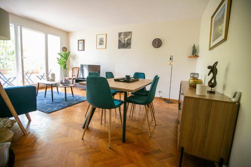 une salle à manger avec une table et des chaises vertes dans l'établissement Jerickais appartement à la Défense, à Courbevoie