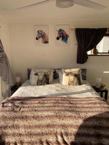 a bedroom with a large bed with two animals on it at Sani Pass View Cottage in Himeville