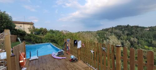 a swimming pool on a wooden deck with a fence at B&B TERRA DI COLLINA in Montegrosso dʼAsti