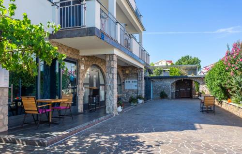 een gebouw met een tafel en stoelen op een patio bij 1 Bedroom Nice Apartment In Bogovici in Malinska