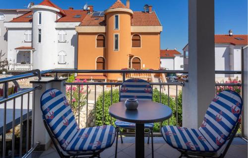 een tafel en stoelen op een balkon met een gebouw bij 1 Bedroom Nice Apartment In Bogovici in Malinska