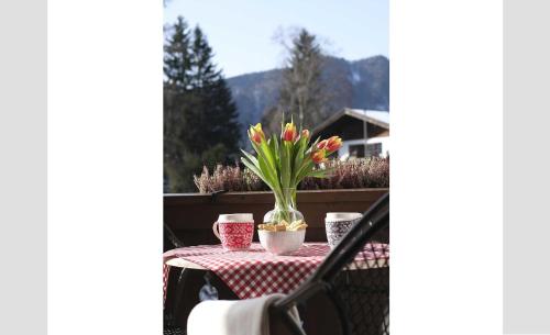 a table with a vase of flowers on it at Apartment 10 an der Rottach in Rottach-Egern