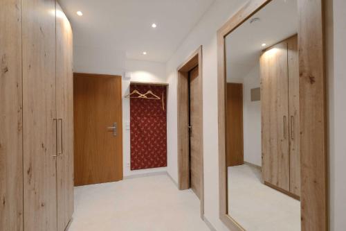 a walk in closet with wooden doors and a red curtain at Apartment 10 an der Rottach in Rottach-Egern