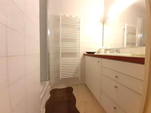 une salle de bain blanche avec un lavabo et un miroir dans l'établissement Studio cosy 4 couchages à Saint-Lary-Soulan avec kitchenette équipée - FR-1-457-334, à Saint-Lary-Soulan