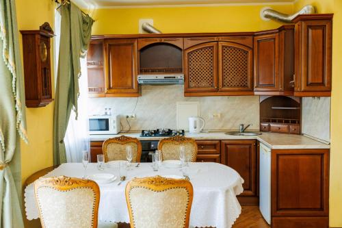 una cucina con tavolo e sedie in una cucina di Квартира Антиквара у центрі Полтави Мережа AlexApartments Документи для відряджень Безконтатне заселення Цілодобово a Poltava