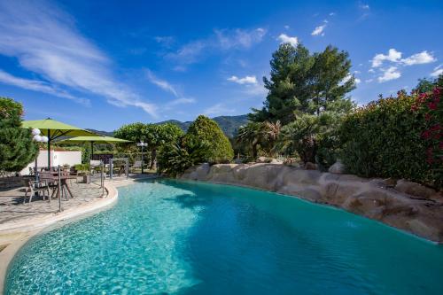 a swimming pool with blue water in a resort at Auberge Du Roua in Argel&egrave;s-sur-Mer
