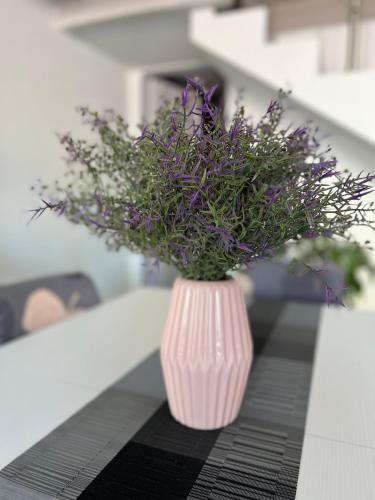 a pink vase with purple flowers sitting on a table at Urban charme loft in Dorgali