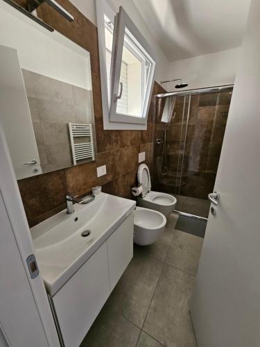 a bathroom with a sink and a toilet and a mirror at CasaMARina in Misano Adriatico
