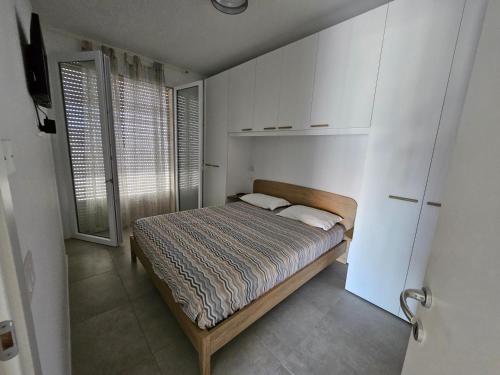 a small bedroom with a bed and a window at CasaMARina in Misano Adriatico