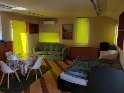 Una sala de estar con una cama, una mesa y sillas. en Jakócs szállása, en Balatonfüred