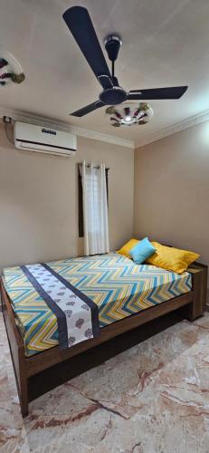 a bedroom with a bed with a ceiling fan at SHI's Thulasi 2BHK in Coimbatore Near to Karpagam College, Palakkad Highway, Rathinam College and More in Coimbatore