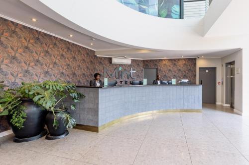a man sitting at a counter in a lobby at MINT Hotel 84 on Katherine in Johannesburg