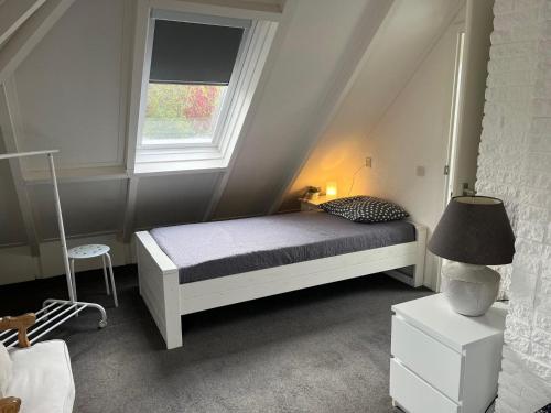 a small bedroom with a bed and a window at Toekomst 27 - Ouddorp NOT INTENDED FOR COMPANY OR WORK-RELATED STAYS in Ouddorp