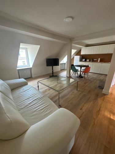 a living room with a white couch and a table at Reichel Sophien Appartements in Baden-Baden