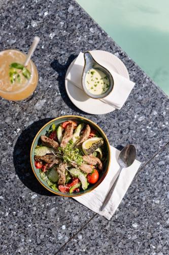 a bowl of food with meat and vegetables on a table at MINT Hotel 84 on Katherine in Johannesburg