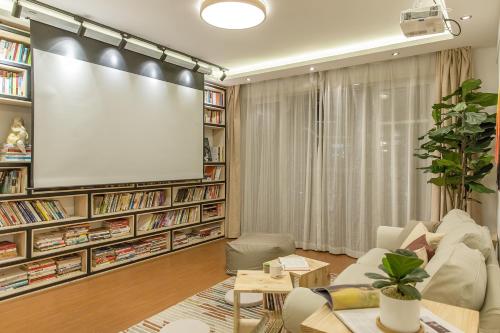 a living room with a large screen on a wall at Book and Bed-People's Square in Shanghai