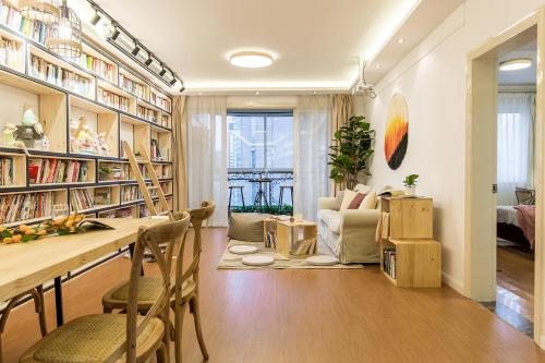 a living room with a table and chairs and bookshelves at Book and Bed-People's Square in Shanghai