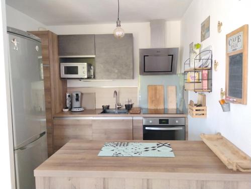 une cuisine avec une table en bois et un réfrigérateur dans l'établissement Kertoudou, à Vannes