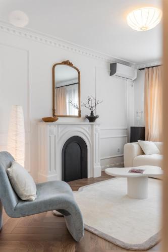 a living room with a fireplace and a chair and a mirror at Ikigai Tivat Parisian Apartment in Tivat