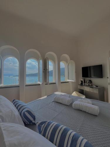 a bedroom with a large bed with four windows at Le Finestre Veneris in Portovenere