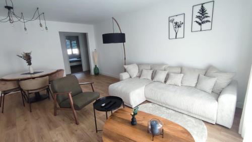 un salon avec un canapé blanc et une table dans l'établissement Le Victor Hugo - Avignon intra muros - Calme - Clim - Lumineux, à Avignon