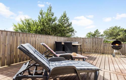 a deck with chairs and a table and a grill at Holiday Home Tranebærvej Thisted Iv in Nørre Vorupør