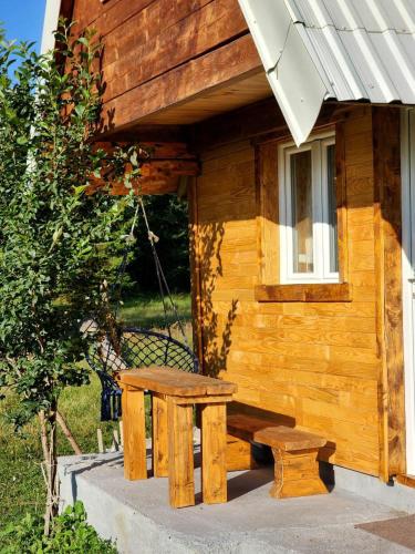 a picnic table and bench outside of a log cabin at Forest Cabin 3 in Žabljak