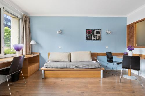 une chambre avec un lit, un bureau et des chaises dans l'établissement Grand appartement avec balcon - Proche Parc des Expo - Parking Privée, à Issy-les-Moulineaux