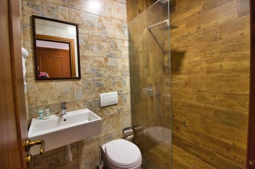 a bathroom with a sink and a toilet and a shower at 4 Rooms 1940 in Gjirokastër